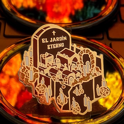 Gold and orange glitter enamel pin of an isometric cemetery with the text 